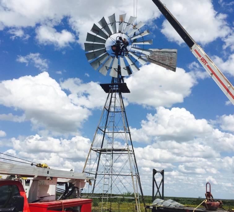 windmill with a crane attached to it, standing in a field windmill with a crane attached to it, standing in a field